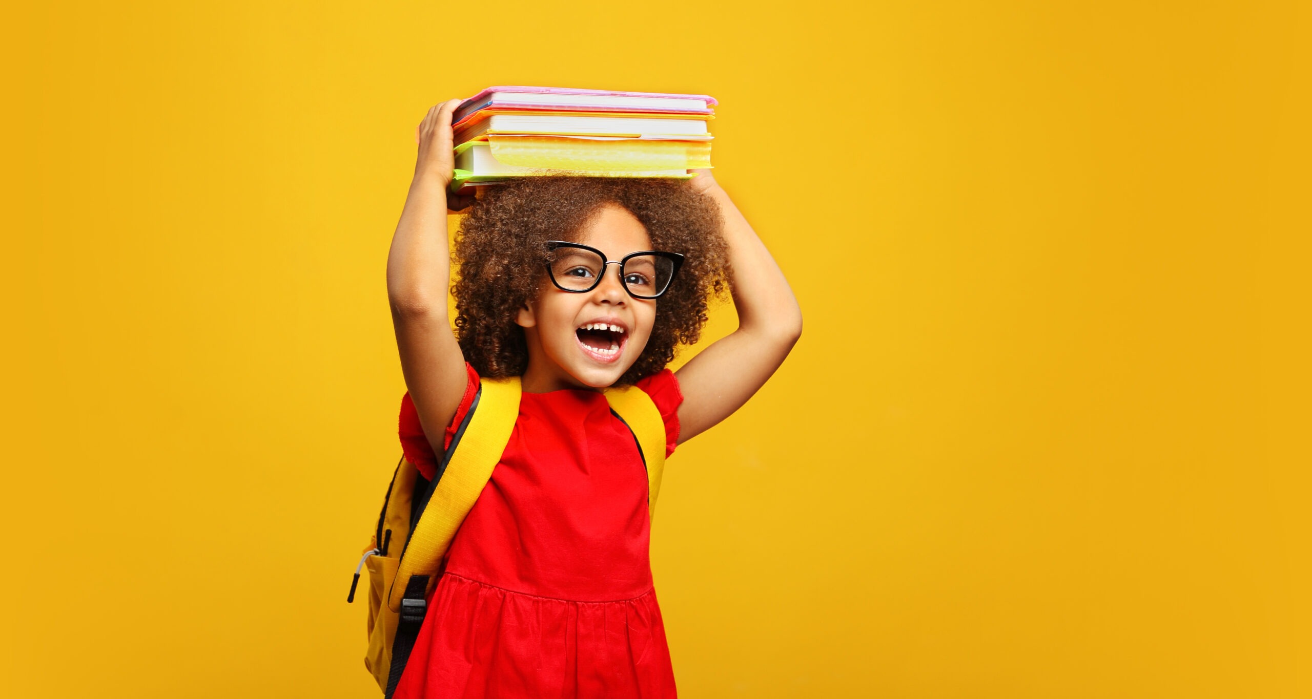 funny smiling Black child school girl with glasses hold books on her head. Yellow background; Shutterstock ID 2014899074; purchase_order: Limited 5/20/2024; job: ; client: ; other: